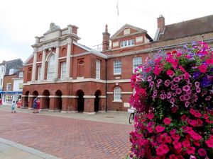1층에 기둥이 있는 빨간 벽돌 건물, 앞면은 흰색 기둥으로 장식되어 있음