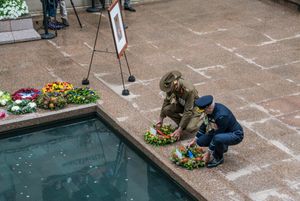 오스트레일리아 국방군 소속 군인들이 마지막 나팔 의식 동안 반사 연못 옆에 화환을 놓는 모습.