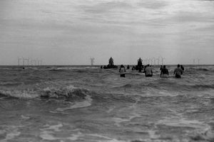 힌두교의 가네쉬 비사르잔 (침수 의식)이 북해에서 거행되는 동안 클랙턴온시 해변에서 멀리 풍력 터빈이 보인다.