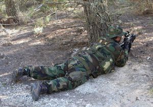 군복, 트레킹 부츠를 착용하고, 예비 탄창을 휴대하고 있는 모습.