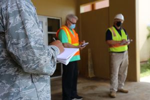 괌 주 방위군과 공군 제254 REDHORSE 비행대대의 군인들이 2020년 4월 데데도의 고등학교를 대체 COVID-19 치료 시설로 전환하기 위한 조율을 하고 있다.