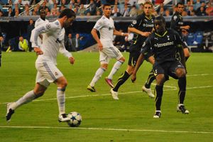 바송이 2011년 UEFA 챔피언스 리그 경기에서 레알 마드리드의 곤살로 이과인에게 공을 빼앗으려 하고 있다.