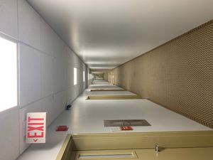 출구 표시가 있는 형광등으로 밝혀진 흰색 복도.