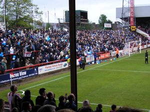 셰필드 웬즈데이 서포터들이 2005년 리그 원 플레이오프 동안 지붕이 없는 이일링 로드 테라스에 있는 모습. 임시 스카이 스포츠 TV 갠트리가 스탠드 뒤에 위치해 있다.