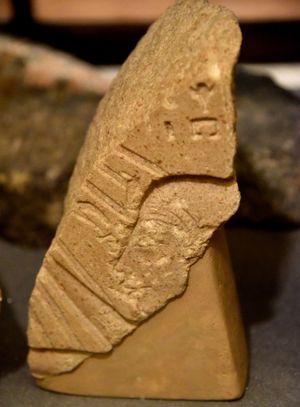 아크나톤으로 추정되는 왕의 머리와 초기 아텐 카르투슈를 보여주는 부조 조각. 아텐은 인물에게 생명의 상징인 앙크를 건네고 있다. 아크나톤 치세. 이집트 아마르나 출토. 런던 이집트 고고학 페트리 박물관.