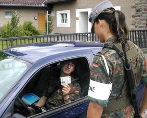 회색 산악모를 착용한 독일 연방군 육군 병사. "Wache"(바헤)라고 적힌 완장은 경계 근무를 하고 있음을 나타낸다.