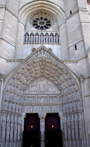 타워 기단의 정문. 하단에는 아치볼트, 팀파눔, 문설주가 있다. 상단에는 둥근 장미 창이 있으며, 일곱 왕의 조각상이 있는 틈새가 있다.