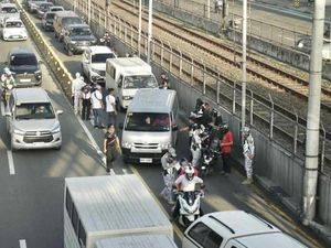 필리핀 마닐라의 교통 단속 요원이 EDSA 버스 노선을 무단 이용하는 차량에 딱지를 발부하고 있다.