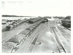 Loaded rail coal trucks, rail tracks and the river on the left
