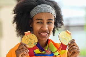 Hassan holds up her two gold medals.