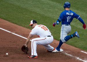 토론토 블루제이스의 케빈 필라가 2017년 5월 경기에서 볼티모어 오리올스의 크리스 데이비스가 다른 내야수로부터 던져진 바운드볼을 잡으려 하는 동안 안전하게 1루에 도달하고 있다.