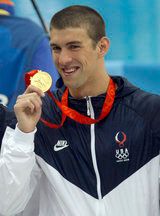 마이클 펠프스가 4 × 100 계영에서 획득한 금메달을 들고 있다