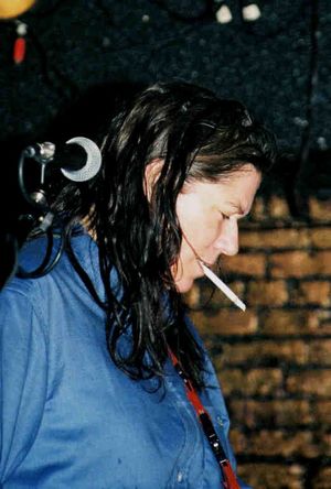 Kim Deal standing next to a microphone