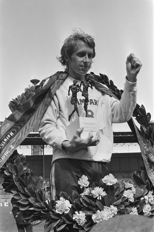 빌 로저스가 1977년 대회 우승 후 트로피와 화환을 들고 있다.