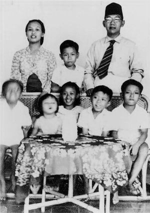 압두라만 와힛이 그의 어머니와 아버지 사이에 서 있고, 그의 형제자매들과 가족 친구가 뒤에 있는 모습, 1952년경