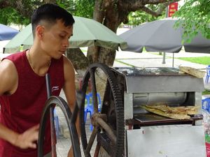 베트남 디엔비엔푸에서 한 남자가 손님들을 위해 사탕수수즙을 짜고 있다.