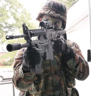 M4에 언더배럴 형태로 장착된 M26-MASS를 든 군인. 이 M26-MASS에는 총열 위로 접혀진 조준기가 없는 점에 유의하십시오.