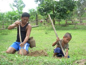 이 아버지와 어린 아들이 함께 가족을 위해 먹을 것을 찾고 있다. 아이에게 유용한 생활 기술을 가르치는 것은 부모화가 아니다.