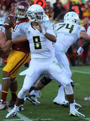 A picture of Marcus Mariota while holding a football during a game.