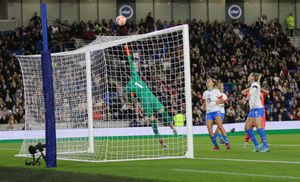 골키퍼가 골대에서 공을 막기 위해 다이빙하고 있다.