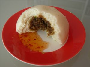 민스 미트(minced meat) 필링을 보여주기 위해 반으로 가른 bakpau, 스위트 칠리 소스와 함께 제공