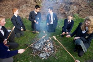 루틴 스쿨에서 불씨 위에 소시지를 굽고 있다