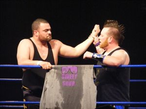 에디 킹스턴 (왼쪽)과 아릭 캐논이 2011년 4월 16일 치카라 킹 오브 트리오스 경기 후 래리 스위니에게 헌사를 하고 있다.