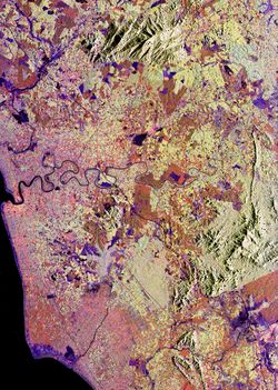 km}} 떨어져 있다. 이미지 왼쪽의 해안은 말라카 해협에 있으며, 이 해협은 말레이시아와 인도네시아의 수마트라 섬을 분리하는 좁은 수로이다. 해안을 따라 있는 파란색 지역은 갯벌이다. 이미지 전체에 걸쳐 노란색과 주황색으로 보이는 미세한 패치워크 패턴은 이 지역의 주요 농산물인 고무, 바나나, 기름 야자 나무 숲이다. 다른 계절 작물의 밭은 더 어두운 주황색과 보라색 음영으로 나타난다. 밝은 녹색의 자연림과 주황색의 개간된 농경지 사이에는 오른쪽 하단에 날카로운 경계가 보인다. 북쪽의 회색 지역은 레당산이다.