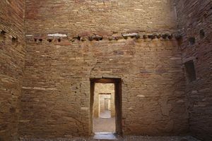 노출된 목재 기둥과 정렬된 출입구가 있는 내부 벽