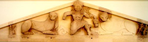 두 사자와 함께 고르곤이 뱀으로 된 허리띠 버클을 보여주는 모습. 기원전 580년 코르푸 아르테미스 신전의 박공벽. 코르푸 고고학 박물관.