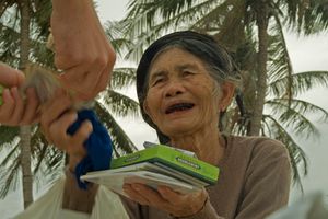 껌을 파는 베트남 노파. 치아가 빈랑 열매를 씹어 생긴 진한 붉은색을 띠고 있다.