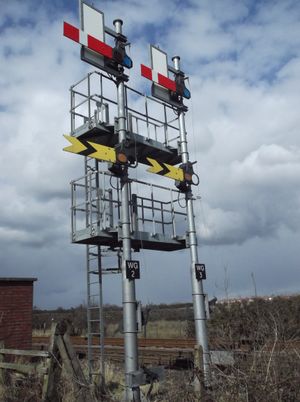 철도 세마포어 신호. "정지" 또는 "주의"는 수평 팔이고, "진행 허가"는 45도 위로 향하므로 작동 케이블이 고장나면 중력에 의해 신호 팔이 안전하게 해제된다.