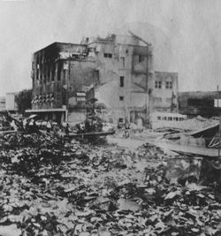 돗토리 시내에서 지진으로 붕괴를 면한 빌딩. 앞쪽은 붕괴되어 화재에 휩싸인 목조 가옥의 잔해.