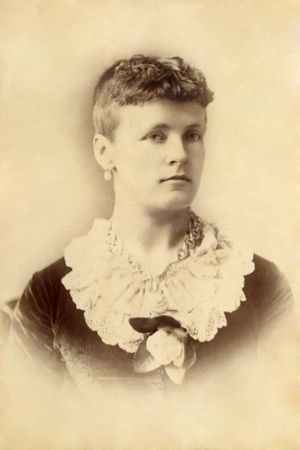 뉴질랜드 여성 참정권 운동가의 초상. 모델은 여성의 권리 신장을 지지하는 상징인 흰색 동백꽃을 착용하고 있다.