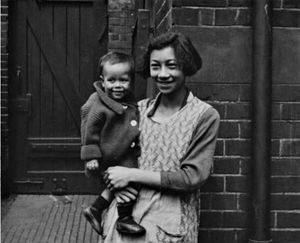 1920년대 런던 이스트 엔드의 라임하우스에서 한 여성이 아이를 안고 있다.