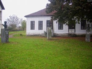 풀밭에 받침대 위에 세 개의 흉상이 있는 건물에 대한 컬러 사진