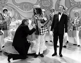 Rowan & Martin's Laugh-In 출연진. 앞줄 왼쪽부터: 존 웨인, 타이니 팀, 딕 마틴. 뒷줄 왼쪽부터: 루스 부지, 조 앤 워리, 앨런 수스, 데니스 로이 앨런, 헨리 깁슨 (1971).