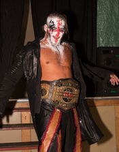 크레이지 스티브가 TNA 월드 태그팀 챔피언십 벨트를 들고 있다.