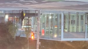Photo of a largely completed modern light rail station entrance with glass panelling.