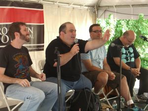 2009년 브루클린 도서 축제에서 코믹스 작가에 관한 패널에서 연설하는 슬롯. 슬롯의 오른편에는 짐 맥캔, 왼편에는 프레드 반 렌트와 피터 데이비드가 있다.