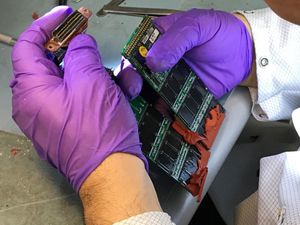 NTSB 직원이 아틀라스 항공 3591편의 조종실 음성 기록 장치의 메모리 보드를 검사하고 있다. 보드는 물에 손상되었을 수 있다.