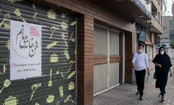 시라즈에서 마스크를 착용한 채 문을 닫은 시장 옆에 있는 사람들