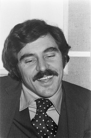 A black and white photo of a man with a mustache