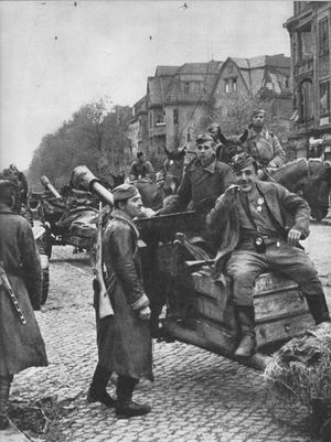 베를린의 한 거리에서 ZiS-3 76mm포 위에 휴식을 취하고 있는 소련군 병사들, 4월 26일