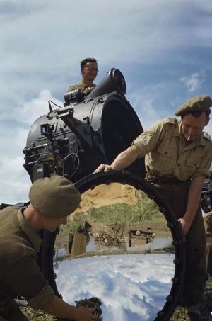 왕립 포병대 소속 대공 탐조등 부대의 병사들이 1945년 4월 이탈리아에서 탐조등의 거울을 닦고 있다.