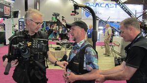 Easyrig 발명가 요한 헬스텐과 촬영 감독 마크 슐츠가 2015년 NAB에서 Easyrig를 착용하고 있다.