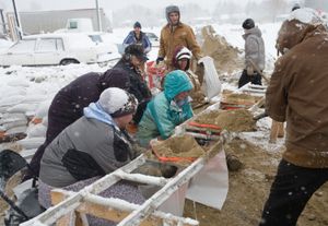 사다리를 사용하여 교통 콘을 깔때기로 활용해 모래 자루를 채우는 모습, 무어헤드, 2009년.