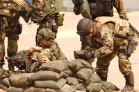 훈련에서 기관총 사수를 보호하기 위해 모래주머니를 쌓는 미국 해군 병사