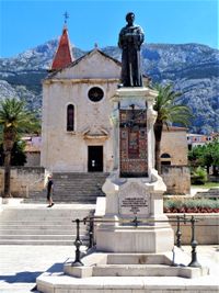 승려이자 시인인 안드리야 카치치 미오시치의 조각상과 배경에 있는 성 마르코 대성당