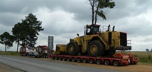 Mammoet Tii 유압식 모듈형 트레일러가 메르세데스 밸러스트 트랙터에 연결되어 프론트 엔드 로더를 이동